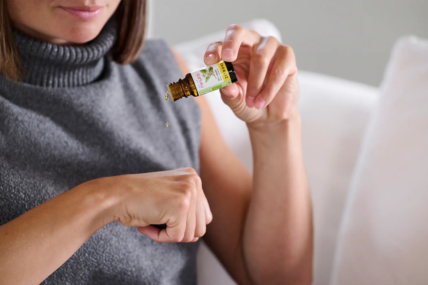 Frau träufelt sich ein paar Tropfen ARTZT neuro Ätherische Öle auf den rechten Handrücken