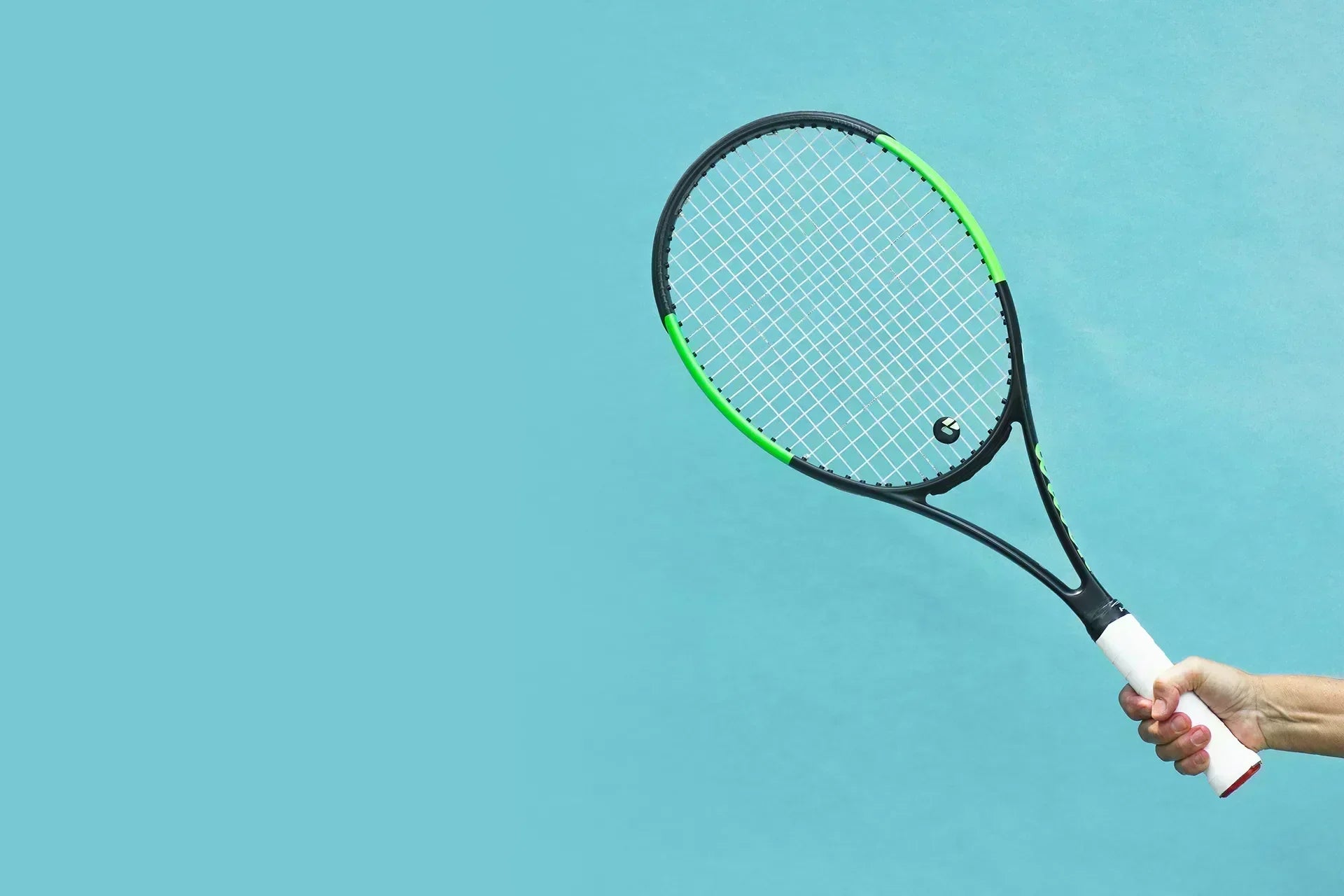 Neuroathletik im Tennis: Eine Hand hält einen Tennisschläger auf blauem Grund