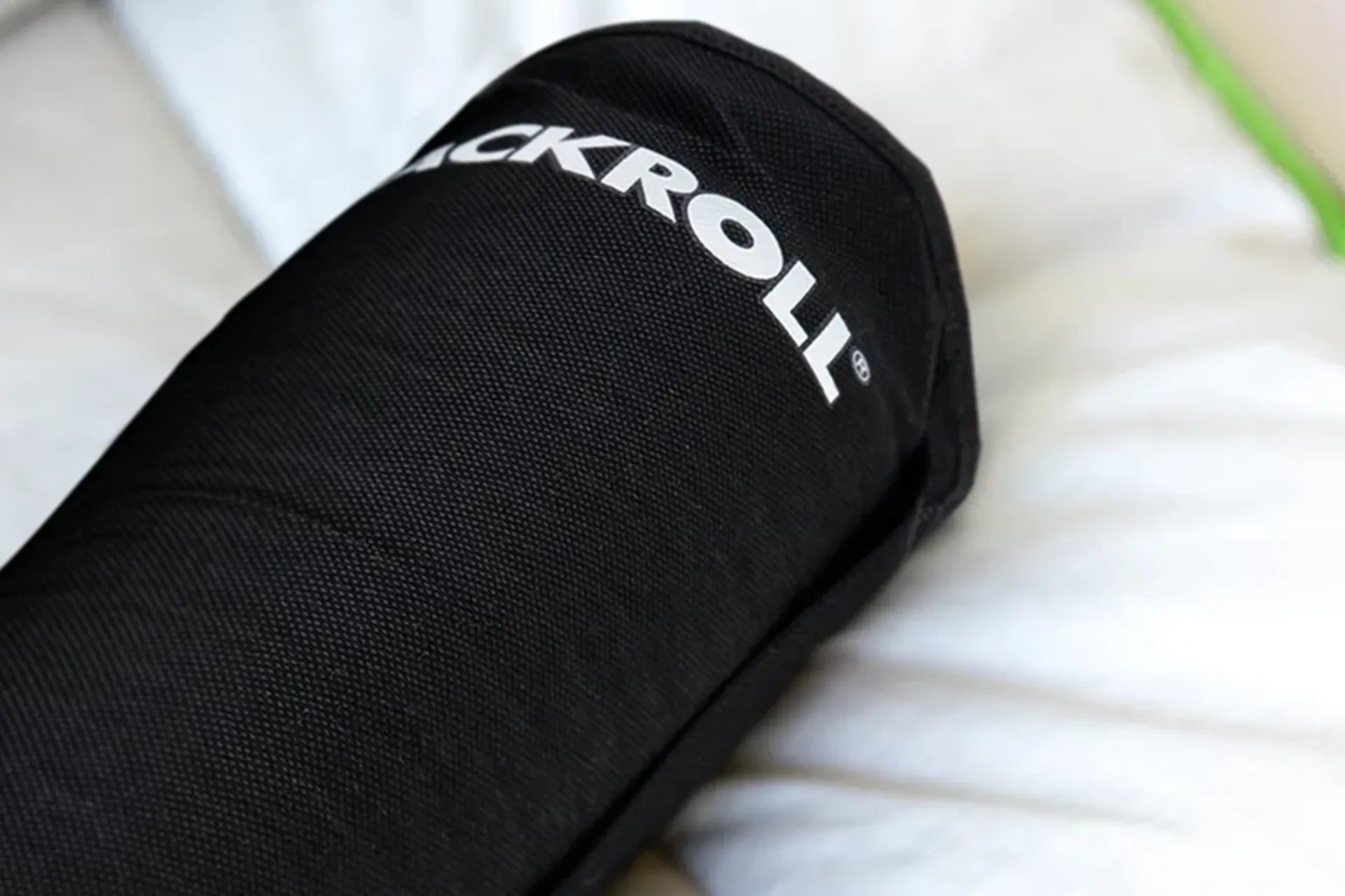 Die Tasche des BLACKROLL Recovery Pillow liegt auf einer weißen Decke.