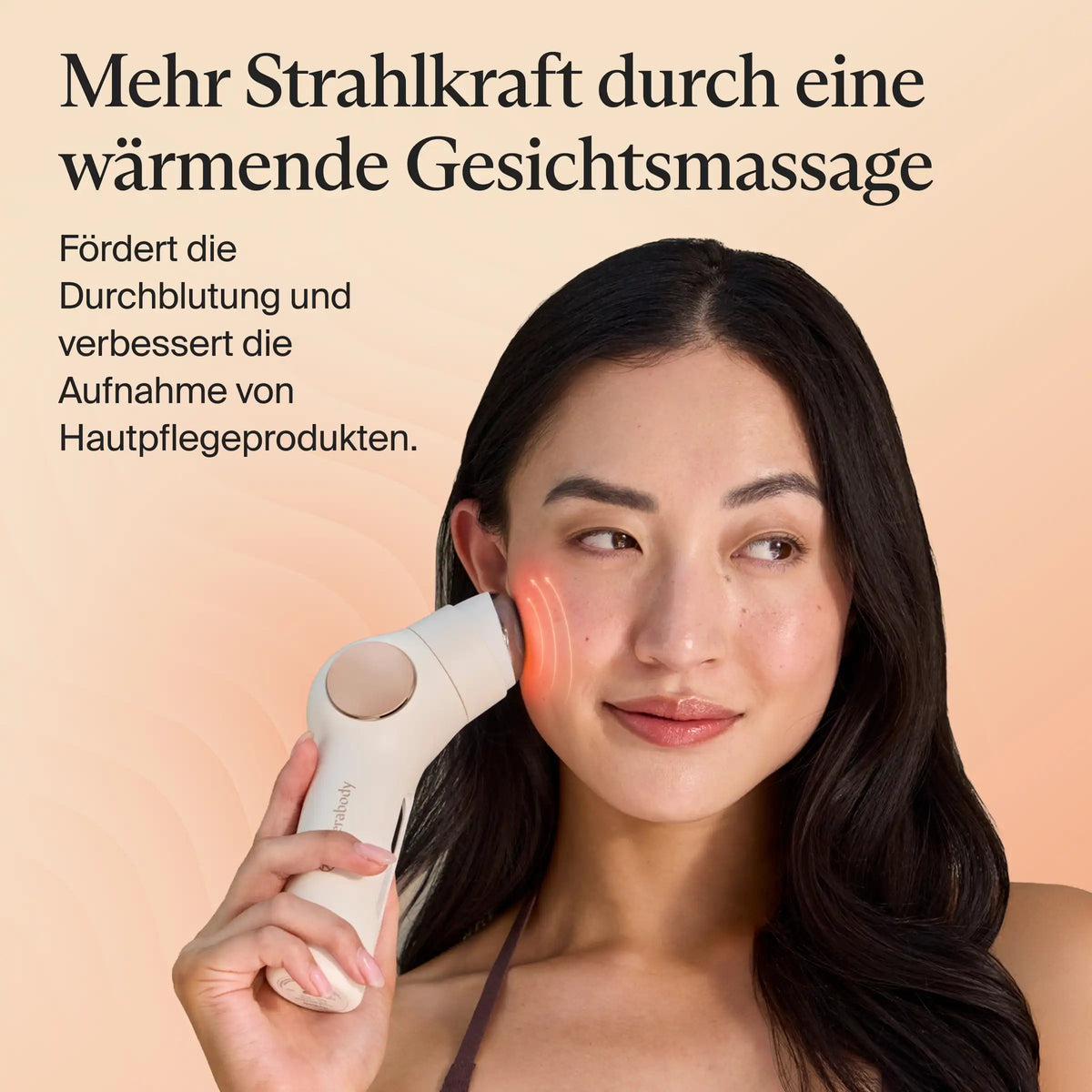 Frau mit langem schwarzem Haar hält das Therabody SkinSpa PRO Gesichtspflegegerät mit Wärme- und Massageaufsatz an die Wange. Die wärmende Gesichtsmassage fördert die Durchblutung und verbessert die Aufnahme von Hautpflegeprodukten