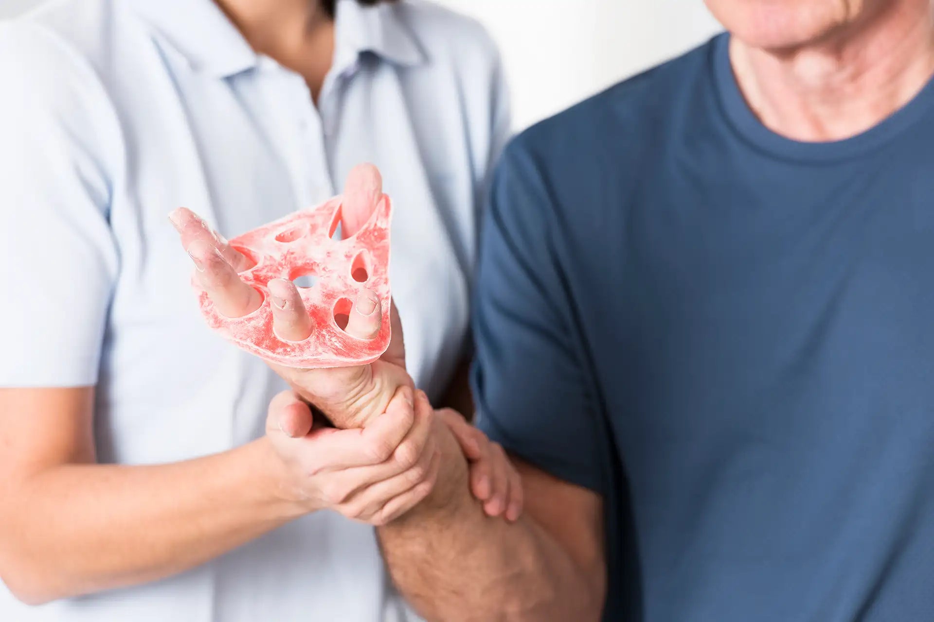 Mann benutzt den TheraBand HandXTrainer für Handtraining