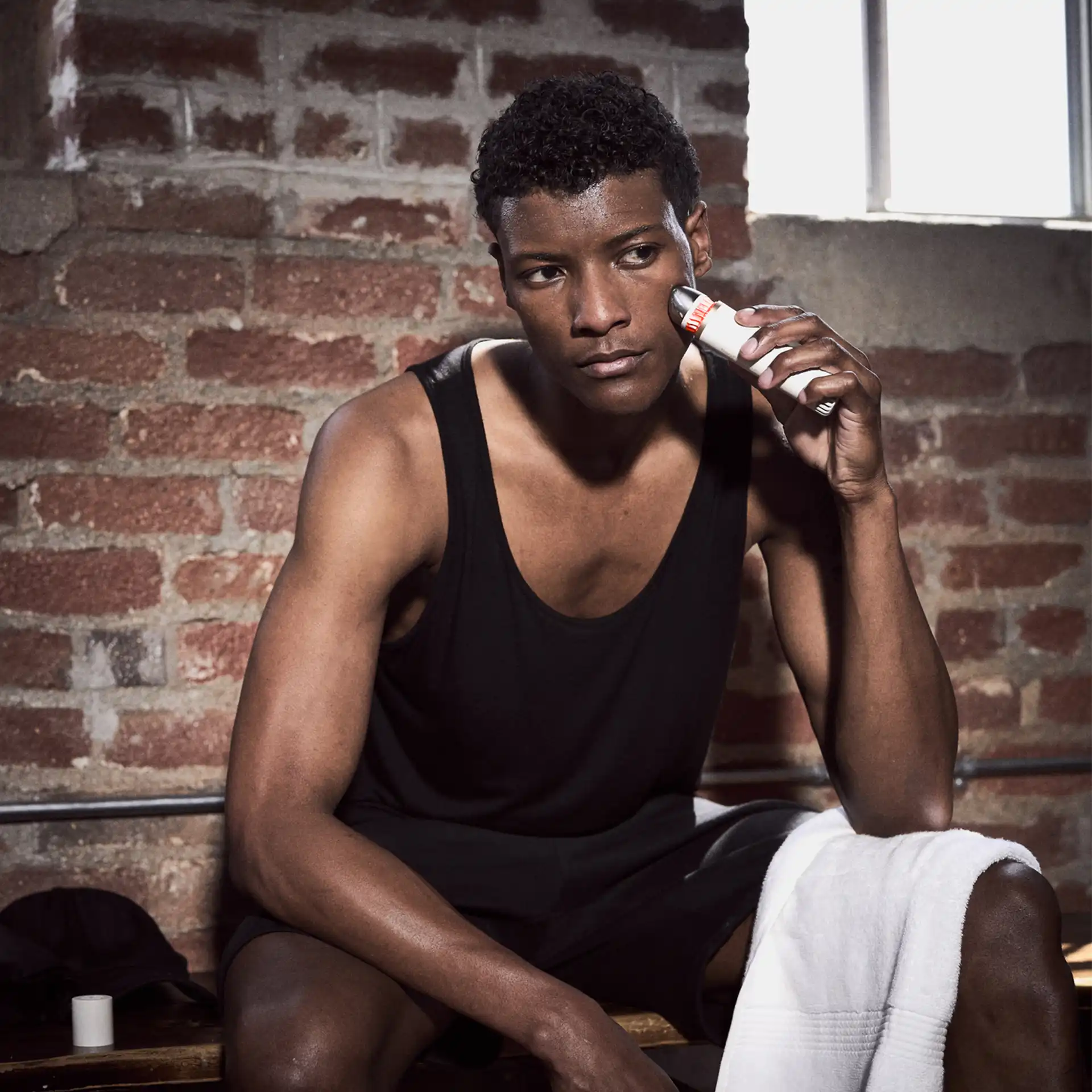 Mann wendet TheraFace Depuffing Wand im Gym nach dem Training an der Wange an