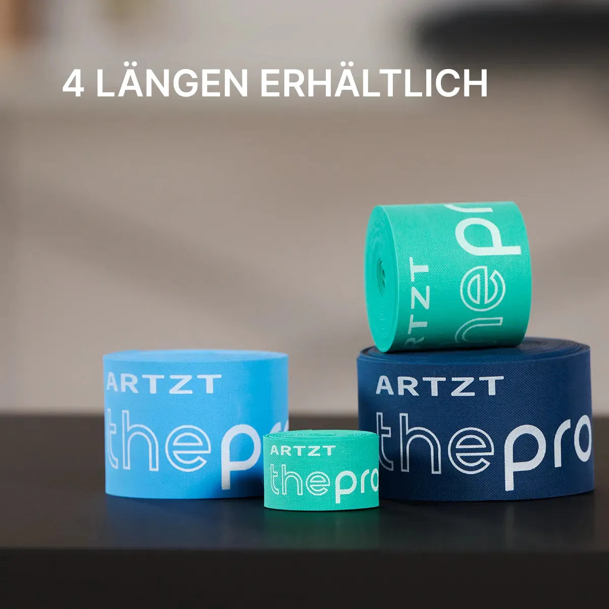 Vier gerollte ARTZT thepro Flossbänder in unterschiedlichen Längen und Farben (hellblau, dunkelblau, türkis) liegen nebeneinander auf einer Fläche.