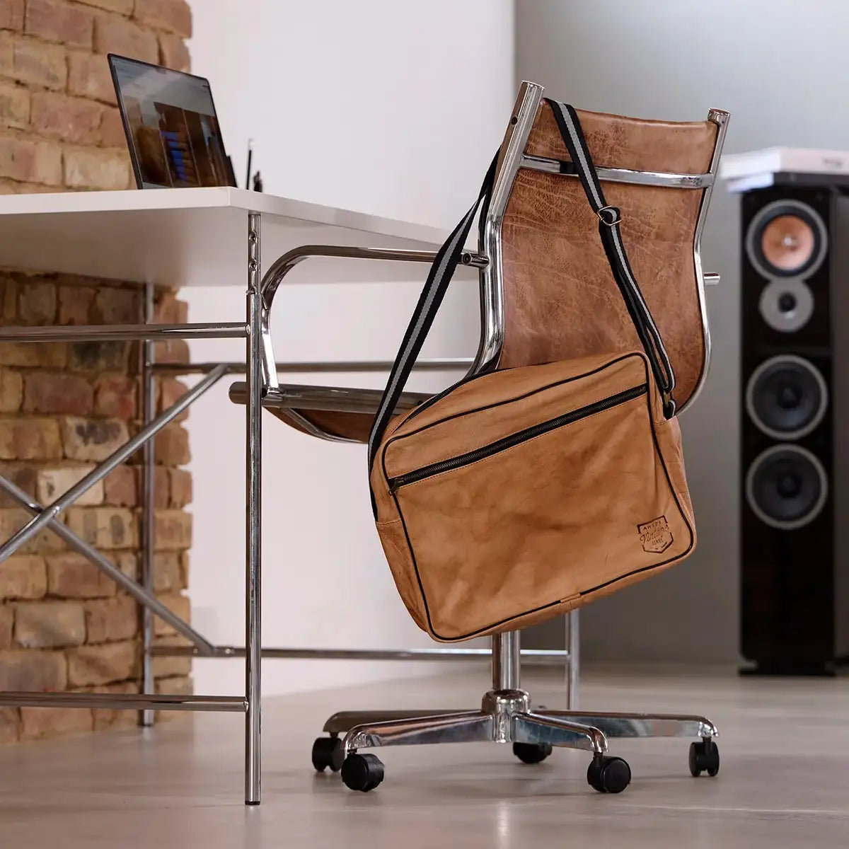 ARTZT Vintage Series Laptop Tasche hängt an einer Stuhllehne.