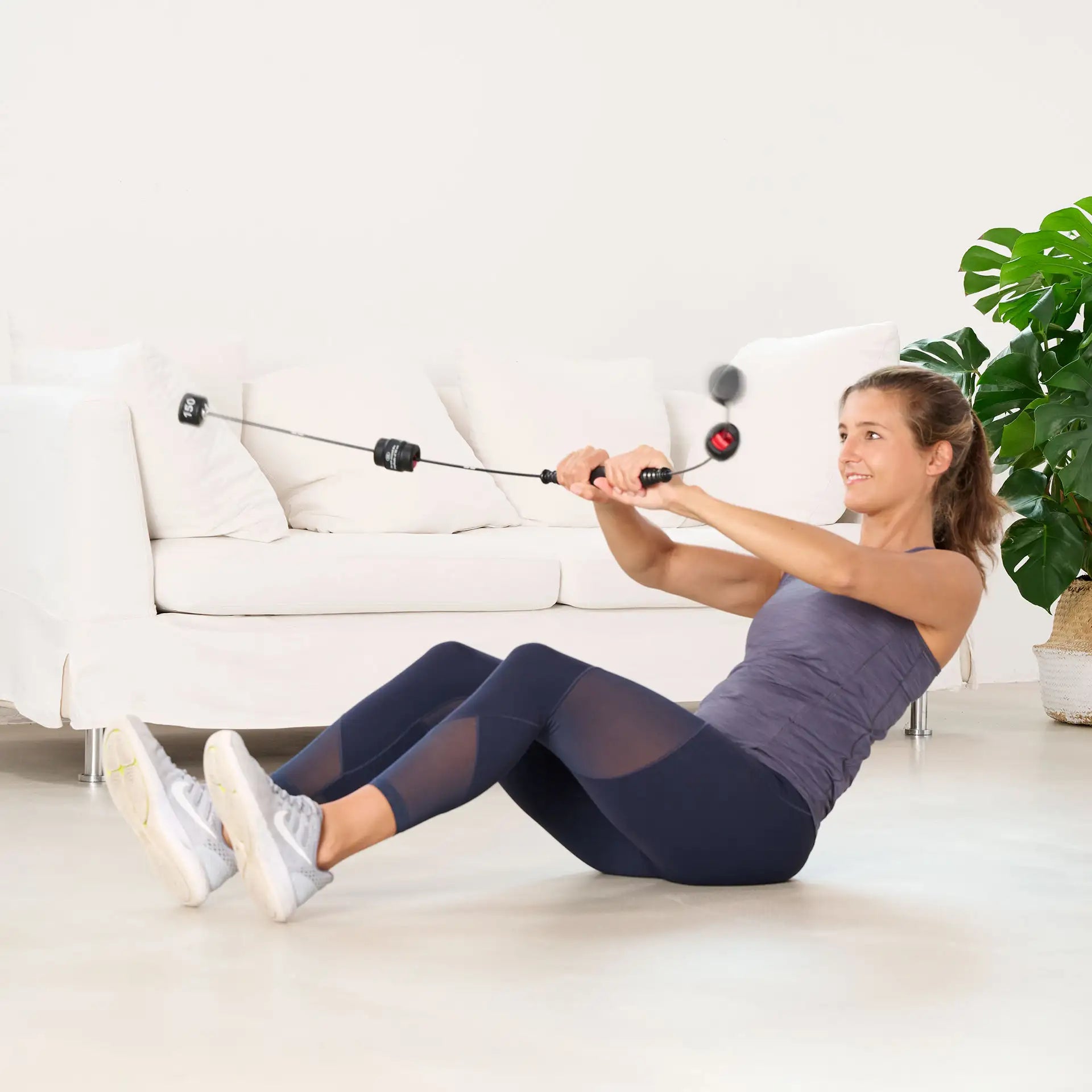 Frau trainiert im Sitzen mit einem Bioswing Schwingstab.