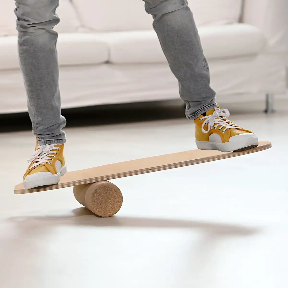 Mann balanciert auf Balance Board von ARTZT vitality im Wohnzimmer