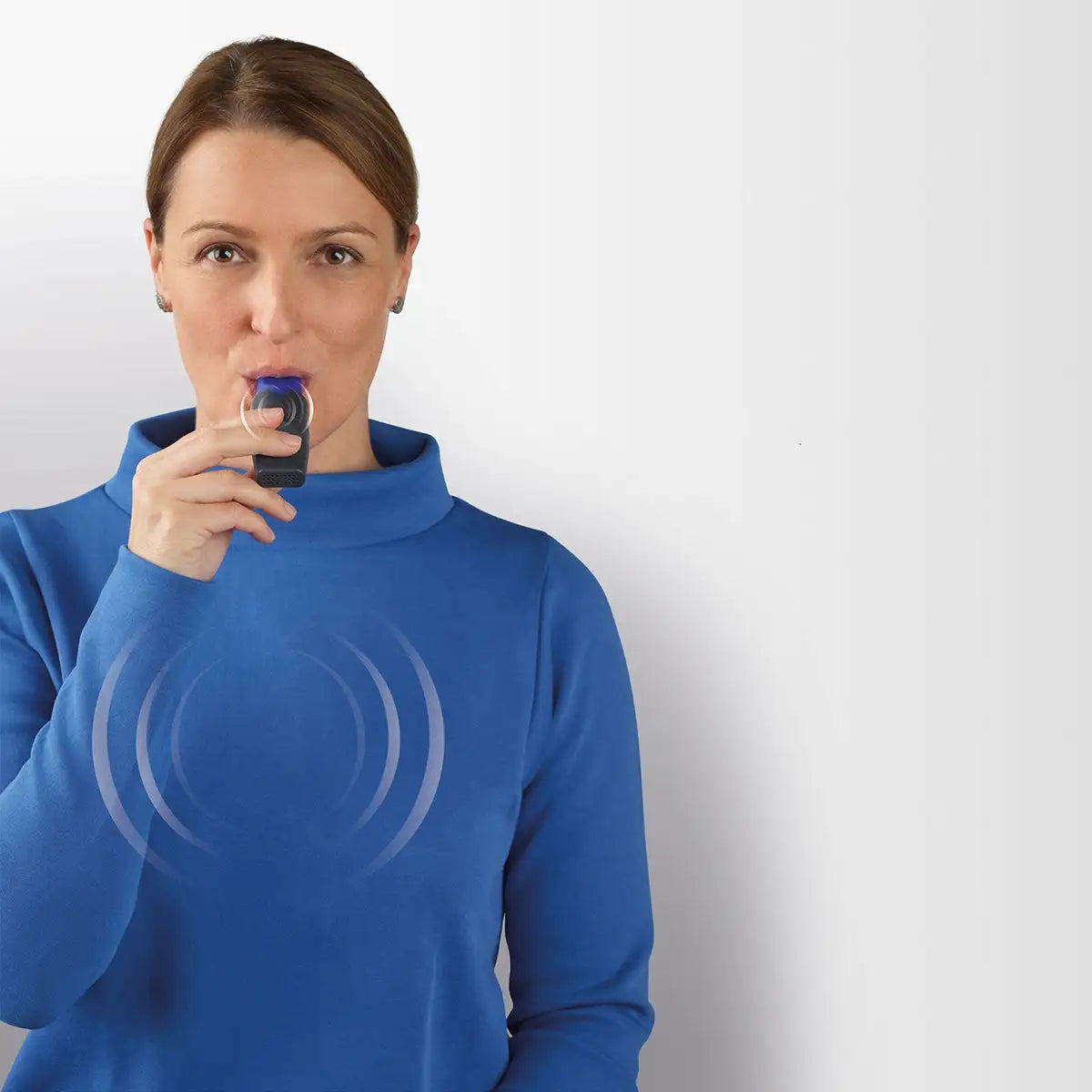 Eine Frau hält mit ihrer rechten Hand den CEGLA RC-FIT CLASSIC Atemtrainer im Mund.