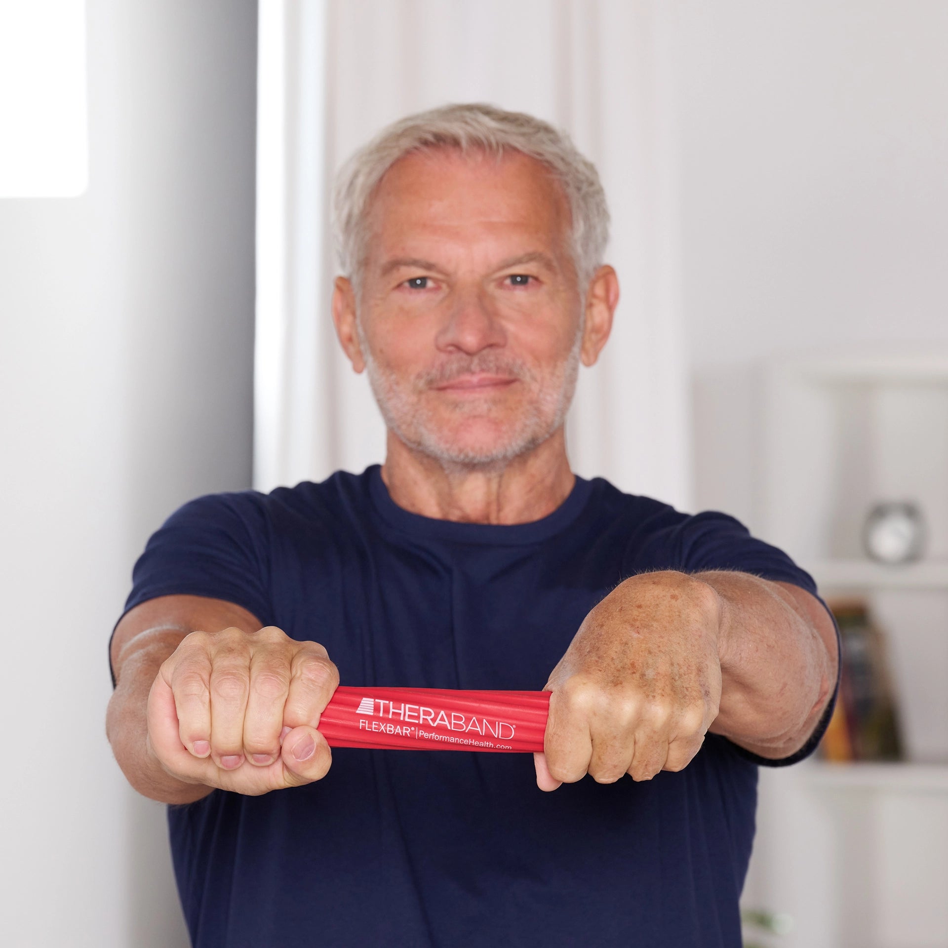 Ein Mann hält einen TheraBand FlexBar Handtrainer waagerecht mit beiden Händen
