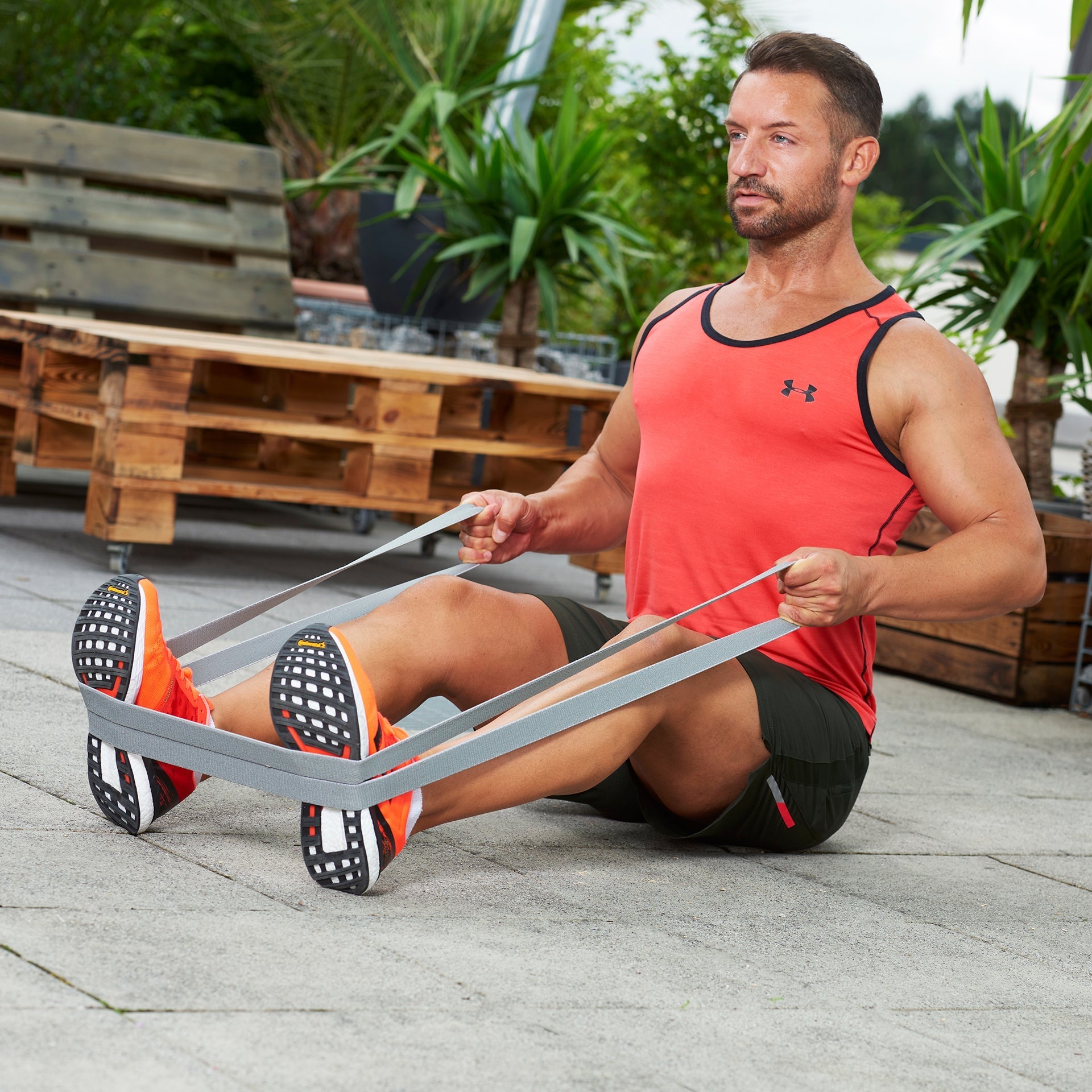 Mann trainiert mit einem grauen ARTZT vitality Super Band