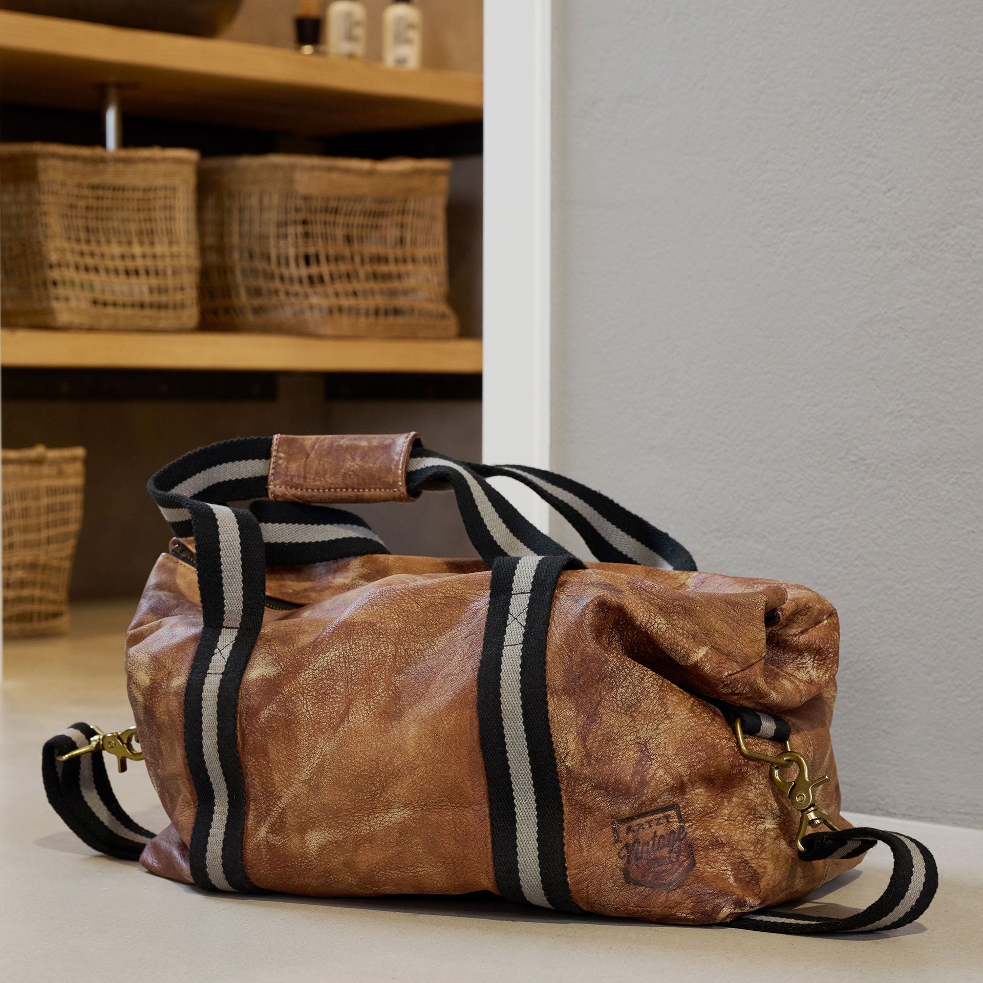 ARTZT Vintage Series Weekender steht auf dem Boden vor einer geöffneten Tür