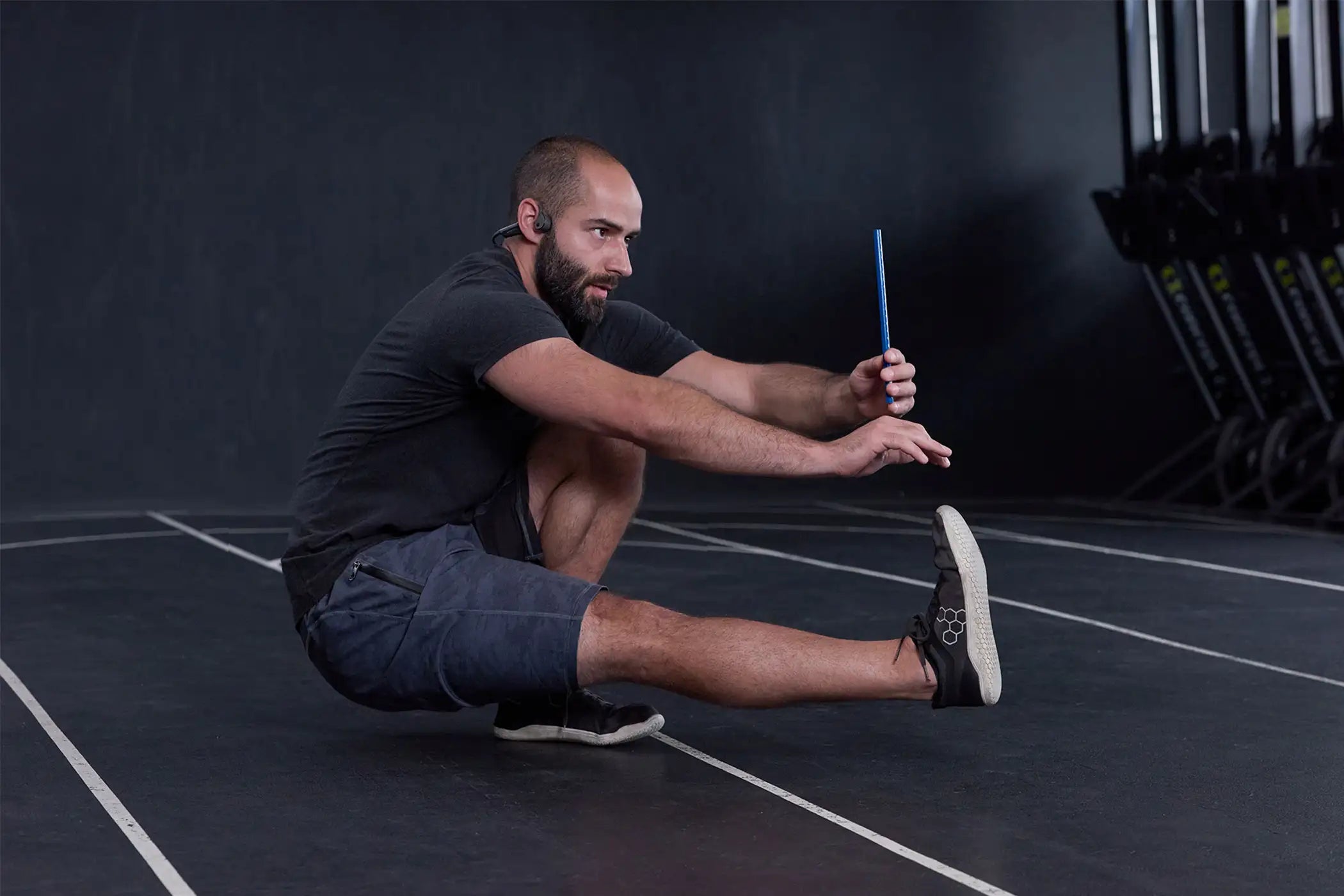 Ein Mann macht eine Balance Übung mit einem ARTZT neuro SoundVibe und einem Vision Stick.