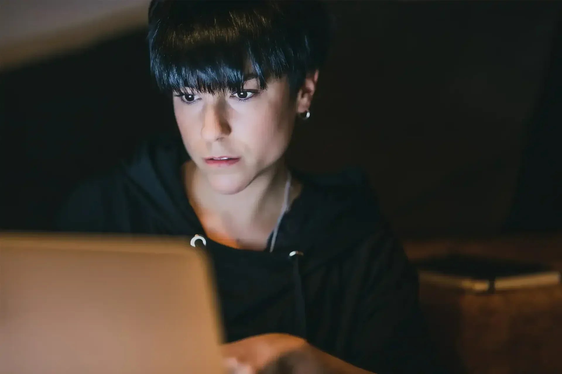 Frau schaut mit Konzentration auf einen Laptop.