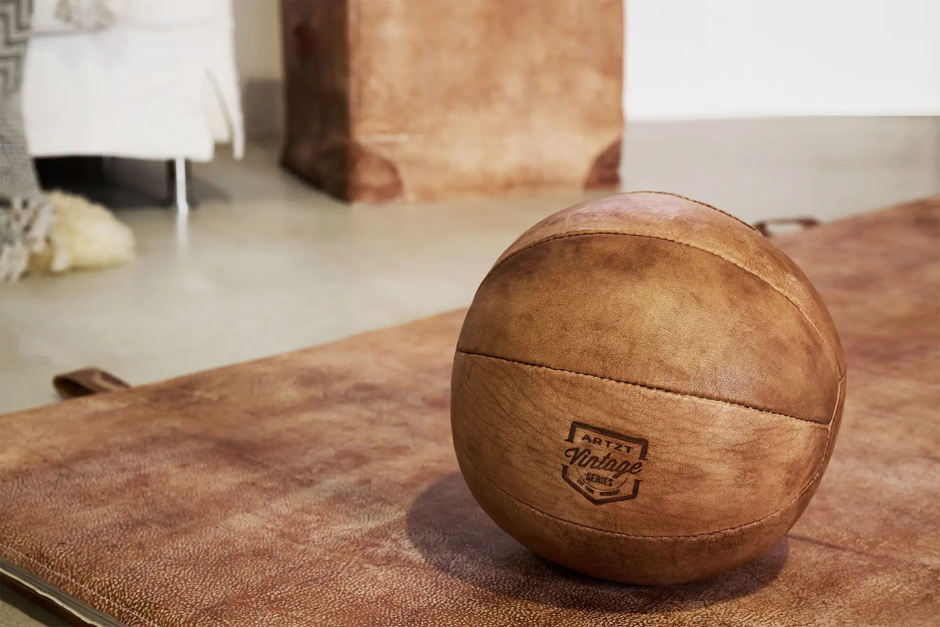 Ein ARTZT Vintage Series Medizinball liegt auf einer Turnmatte
