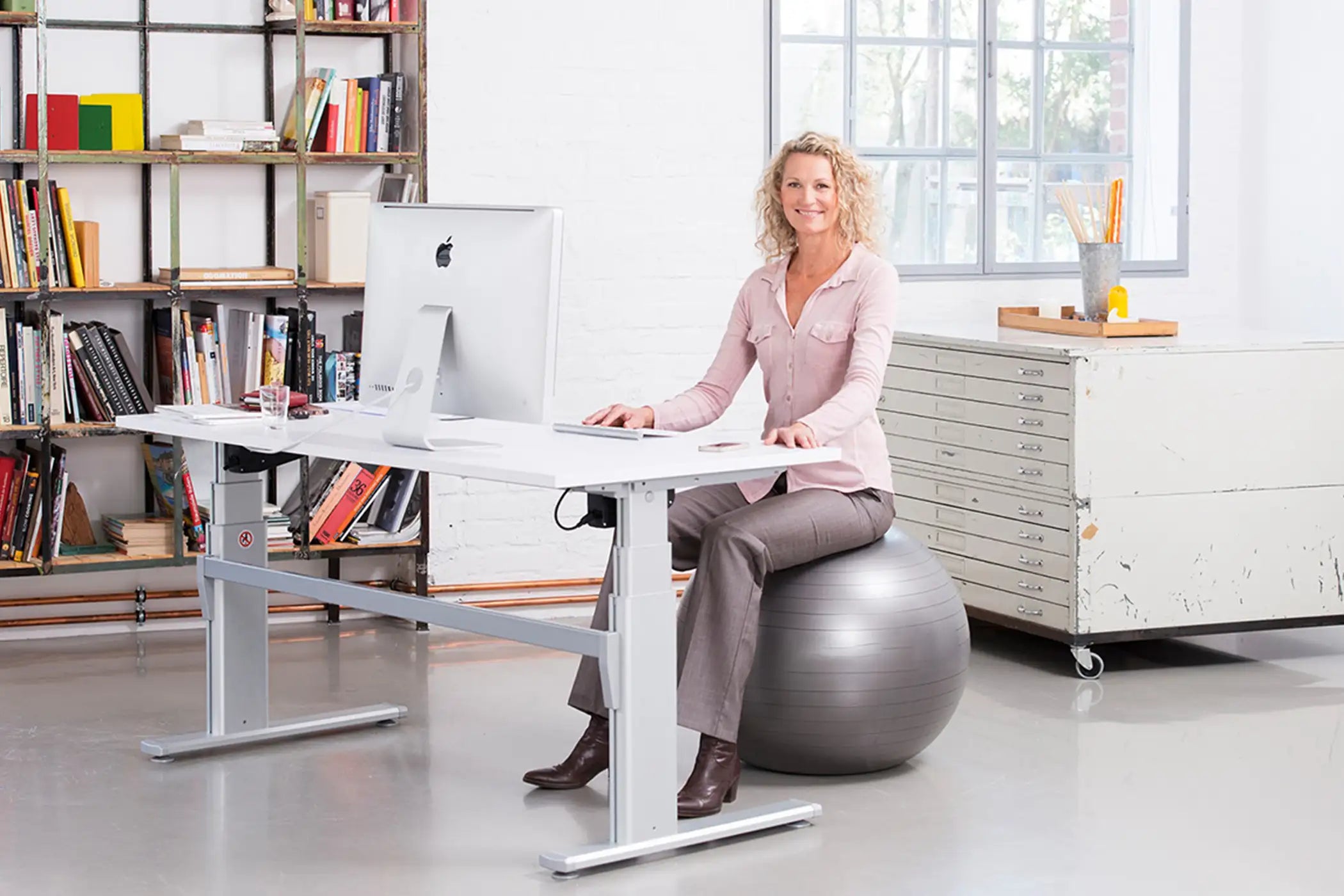 Frau sitzt auf einem Gymnastikball von ARTZT