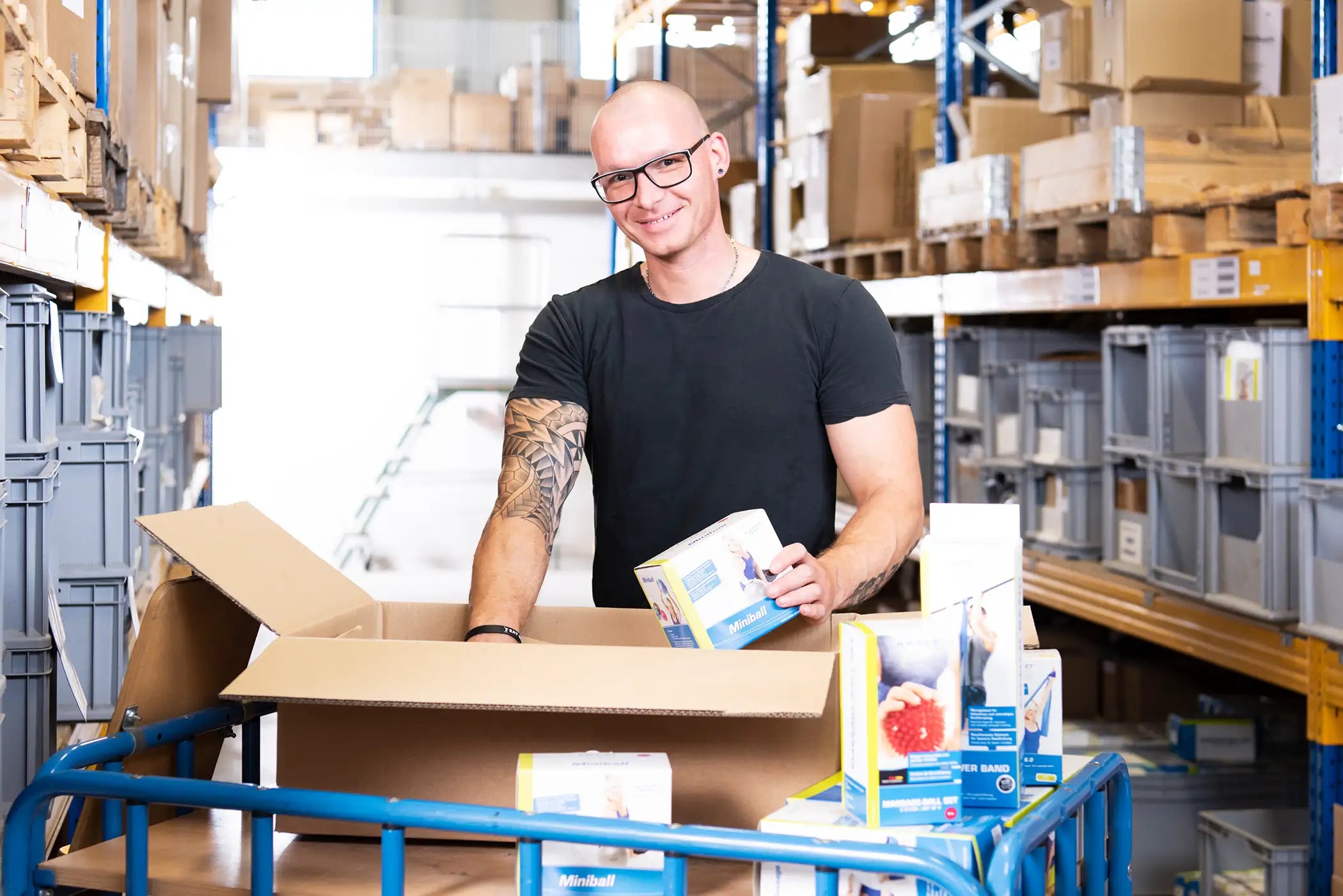 Ein Mann packt Produkte der Marke ARTZT vitality in einen Karton.