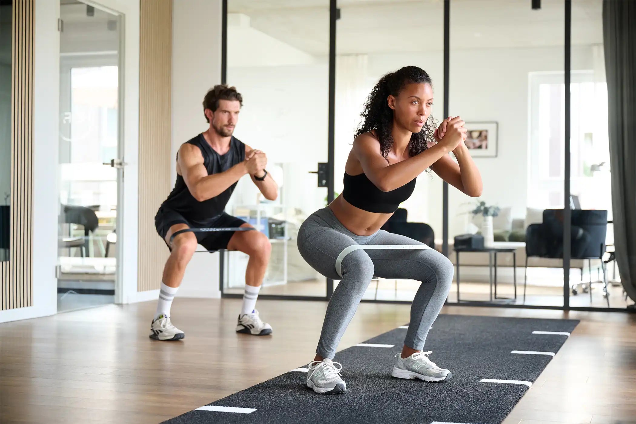 Mann und Frau beim Squat mit dem ARTZT thepro Loop Band