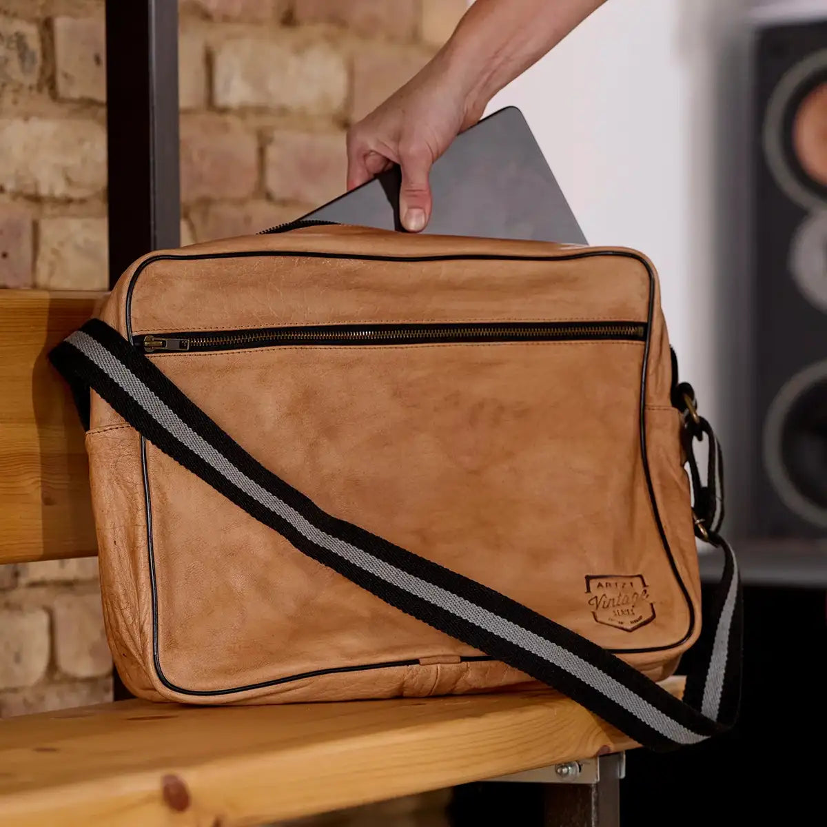 Eine Hand greift nach einem Notebook in der ARTZT Vintage Series Laptop Tasche.