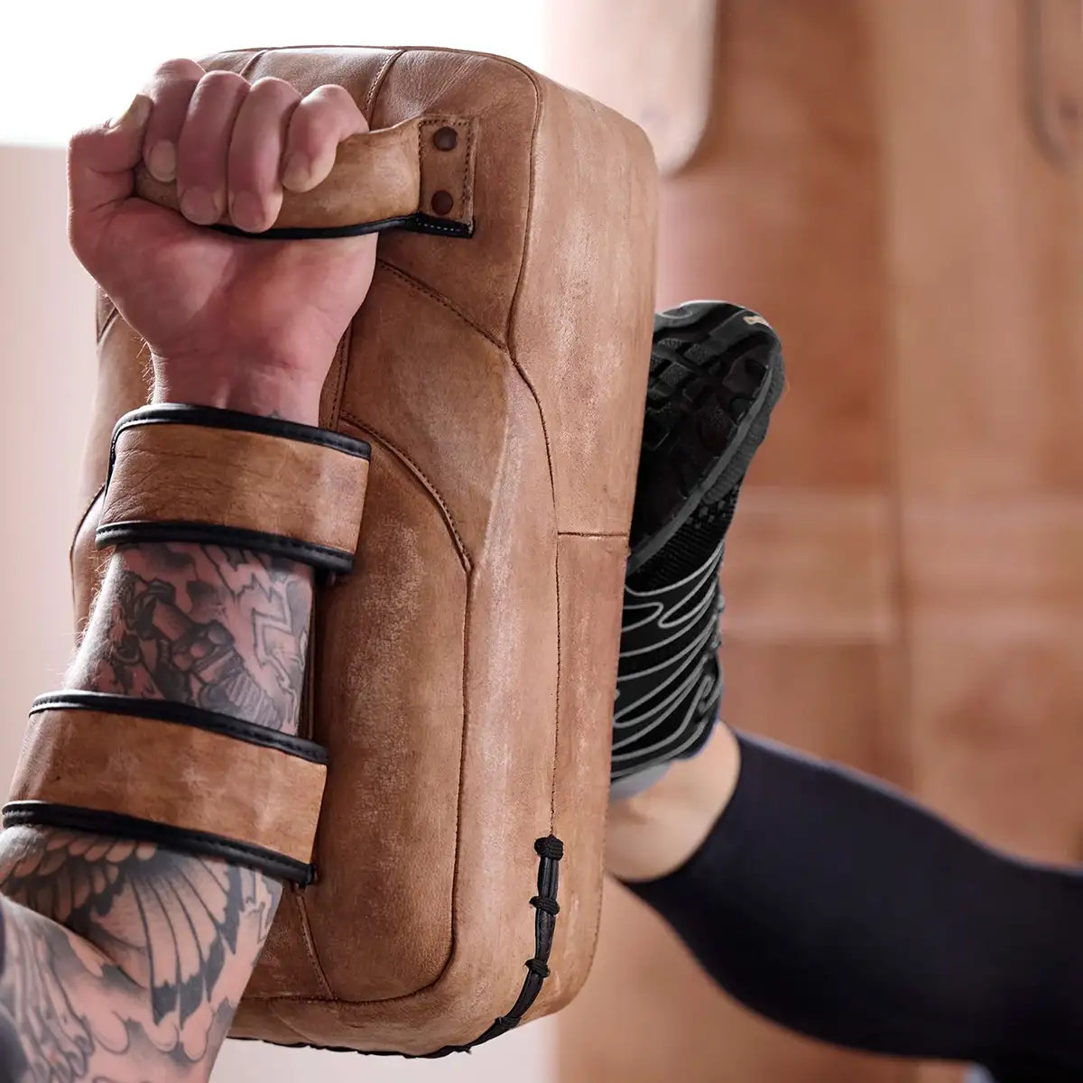 ARTZT Vintage Series Thai Pad wird von einem Arm gehalten, während ein Fuß dagegentritt.