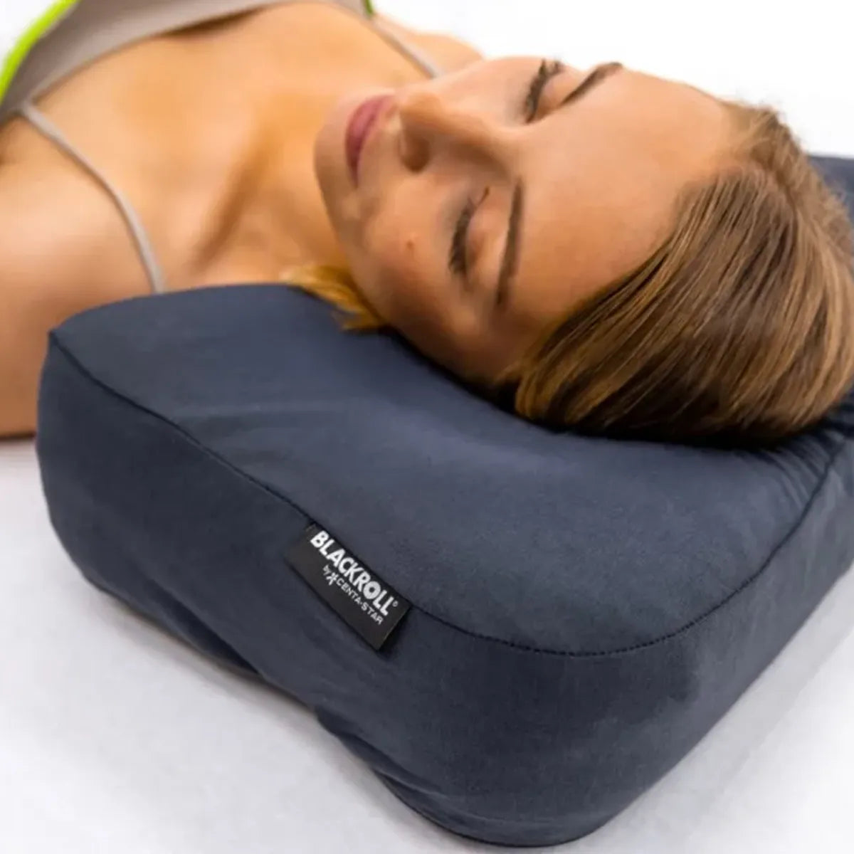 Nahaufnahme einer Frau, die mit dem Kopf auf einem Blackroll Kissen mit Pillow Case in der Farbe Anthrazit liegt.