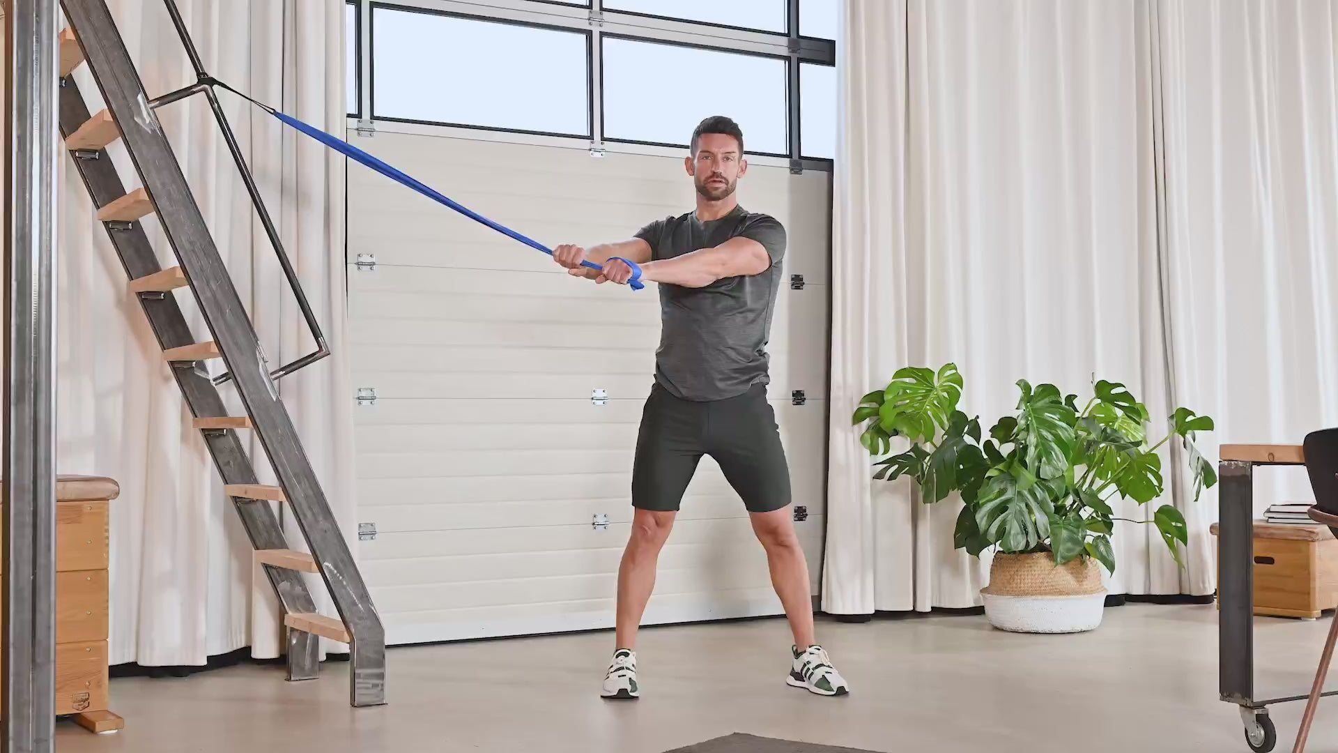 Mann vollführt die Übung Side Abs Rotation mit dem TheraBand.